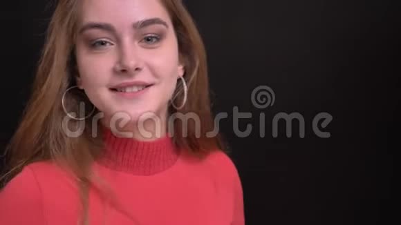 年轻美丽的白种人女性的特写镜头她直勾勾地微笑在镜头前摆姿势视频的预览图