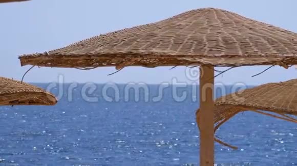 在红海的背景下带着雨伞的空旷海滩视频的预览图