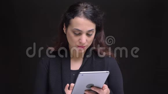 特写照片年轻迷人的高加索女性在镜头前的平板上浏览视频的预览图
