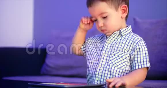 可爱的儿童娱乐与平板小男孩消磨闲暇时间玩手机游戏在光明中破碎视频的预览图