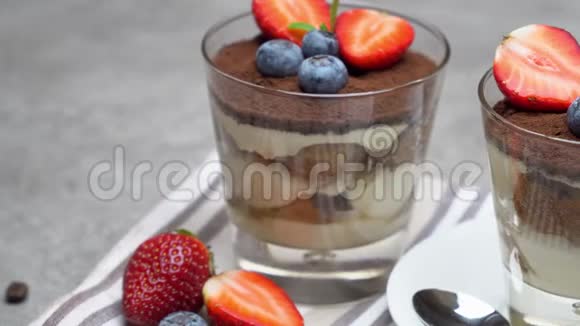 经典的提拉米苏甜点蓝莓和草莓在玻璃混凝土背景视频的预览图