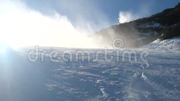 在斜坡上做雪滑雪者靠近雪炮制造新鲜的粉末雪山滑雪场冬季风平浪静视频的预览图
