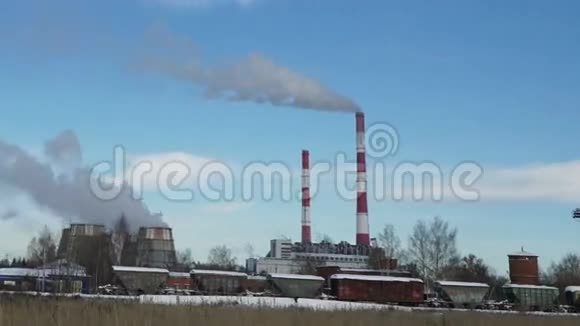 火力发电厂或有吸烟烟囱和孤树的工厂视频的预览图