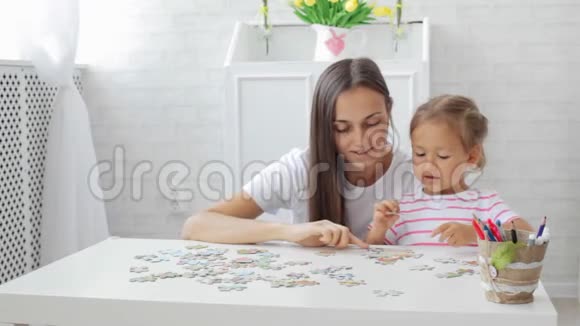 母女俩一起在客厅里玩拼图游戏视频的预览图