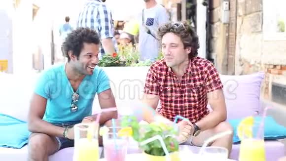 两个男朋友夏天坐在露台咖啡馆里视频的预览图