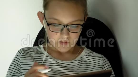 少女使用带有耳机的平板电脑晚上时间视频的预览图