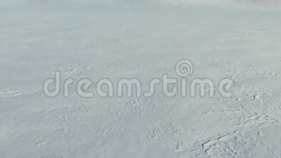 冬季低飞和起飞以上雪场空中全景雪的图案和质感视频的预览图