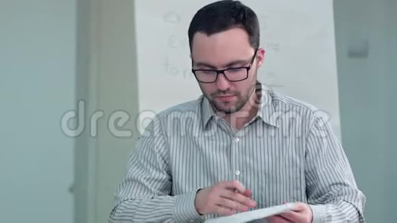 老师坐在课桌前和一个学生说话视频的预览图