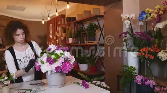 花店花店花店布置现代花束年轻英俊的花店在花店做花束视频的预览图