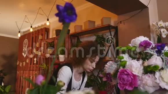 花店花店花店布置现代花束年轻英俊的花店在花店做花束视频的预览图