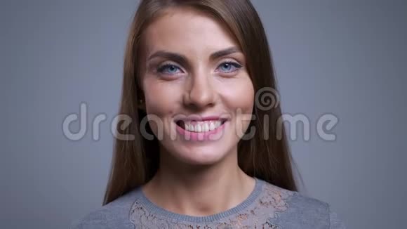 特写照片上的年轻白种人幸福的女人微笑着直视着镜头背景是灰色的视频的预览图