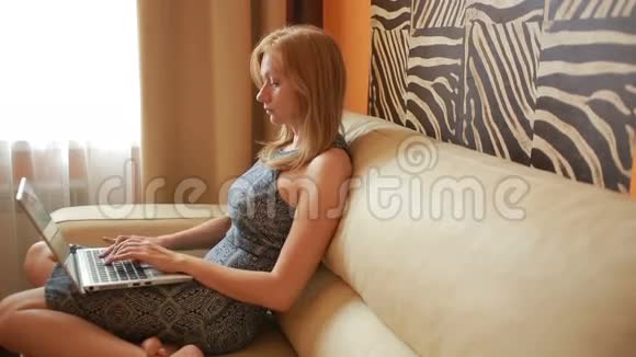 沙发上的女人客厅里有笔记本电脑视频的预览图