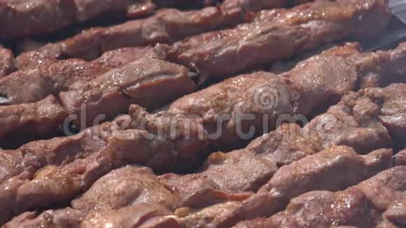 户外炭火烧烤架上的金属串烧成美味可口的猪肉视频的预览图