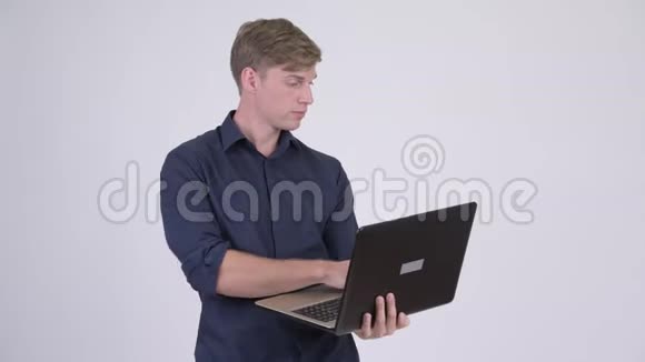 快乐年轻英俊的商人思考笔记本电脑视频的预览图