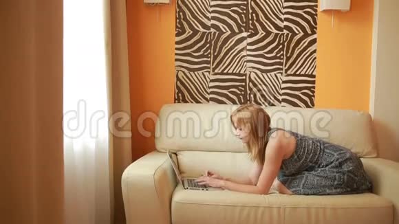 沙发上的女人客厅里有笔记本电脑视频的预览图