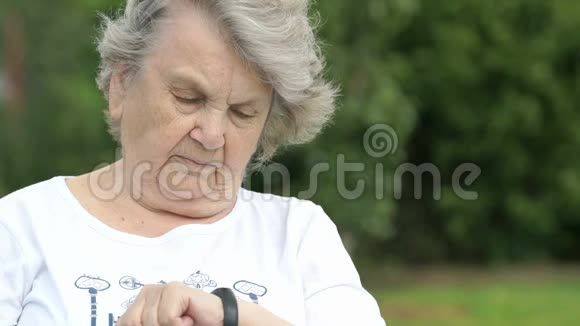 老妇看腕带健身跟踪器视频的预览图