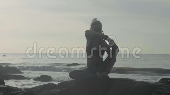 日落时剪影瑜伽练习勇女在沙滩上做瑜伽运动视频的预览图