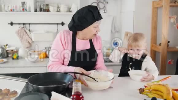 家庭做煎饼一位老妇人把面团放在锅里视频的预览图