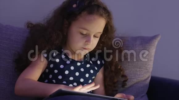 可爱的儿童娱乐与平板小女孩度过闲暇时光玩手机游戏在光明中破碎视频的预览图