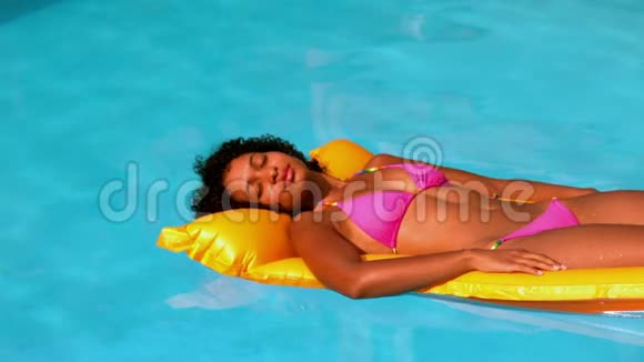 穿着粉色比基尼的快乐女人在游泳池里放松视频的预览图