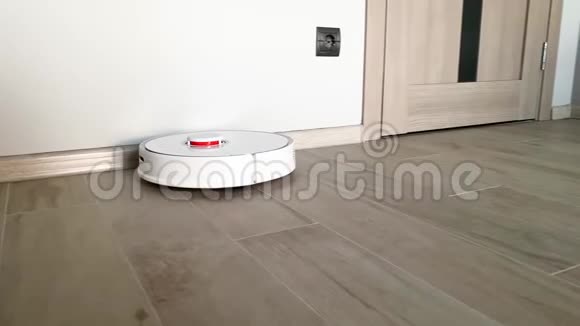 智慧之家吸尘器机器人在客厅的木地板上运行视频的预览图