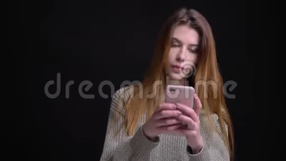年轻美丽的白人女性用手机在镜头前微笑的特写照片视频的预览图