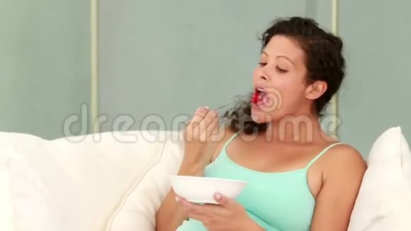 在沙发上吃沙拉的孕妇视频的预览图