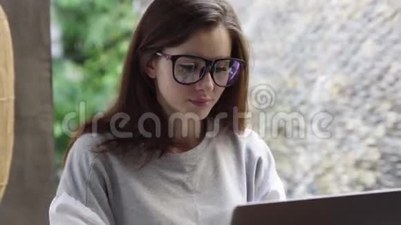 戴眼镜的女人用笔记本电脑女商人在度假期间在电脑上工作视频的预览图