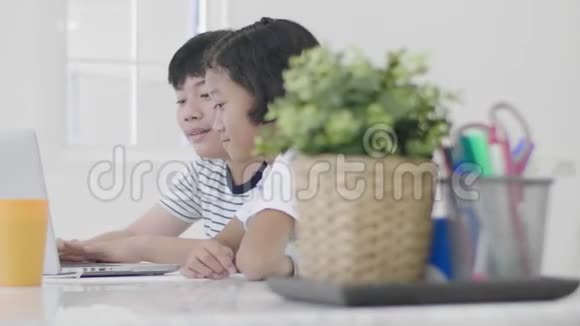 年轻的亚洲男孩和女孩在家玩笔记本电脑视频的预览图