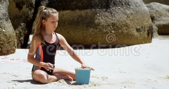 沙滩上玩沙子的女孩4k视频的预览图