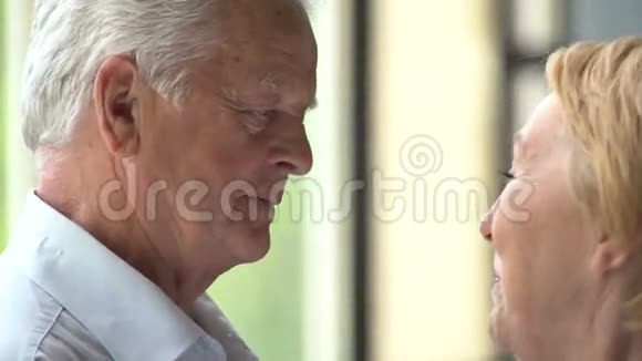 可爱快乐的老年夫妇在现代公寓他们说话微笑视频的预览图