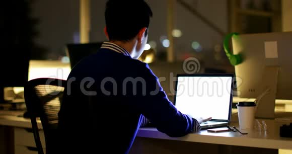 办公室办公桌上使用笔记本电脑的男性高管视频的预览图