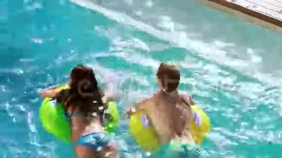 一对夫妇在游泳池里用充气戒指游泳视频的预览图