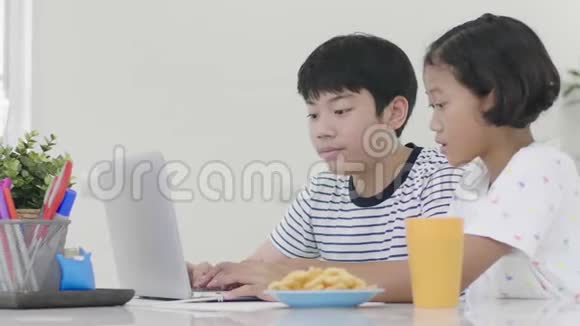 年轻的亚洲男孩和女孩在家玩笔记本电脑视频的预览图