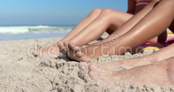 年轻的女性朋友坐在沙滩上视频的预览图