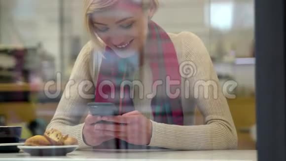 人和技术美丽的女人在咖啡厅用电话视频的预览图