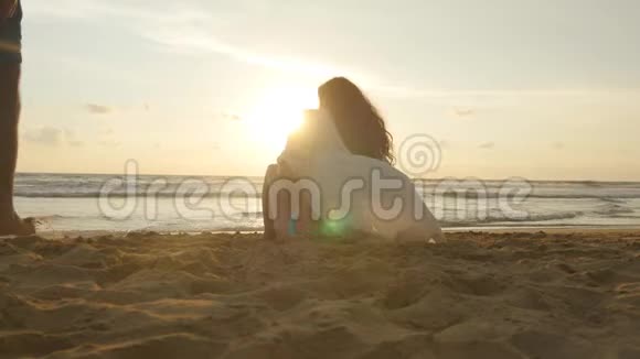 一个女人和一个男人坐在海边的沙滩上欣赏着海洋和风景年轻浪漫情侣视频的预览图