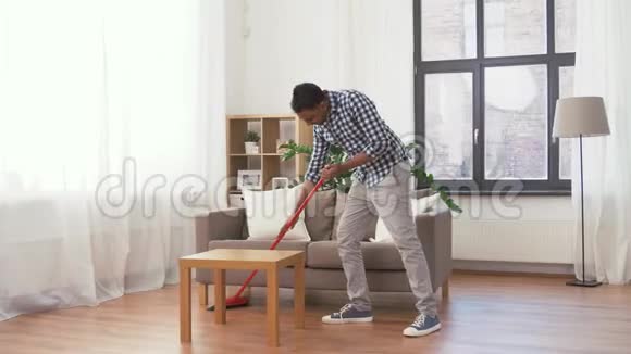 家里有扫帚打扫地板的印度男人视频的预览图