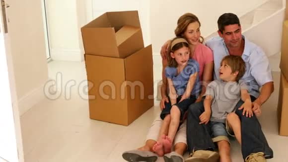 幸福的家庭坐在他们新家的地板上视频的预览图