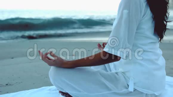 在海滩上放松练习瑜伽的女人视频的预览图