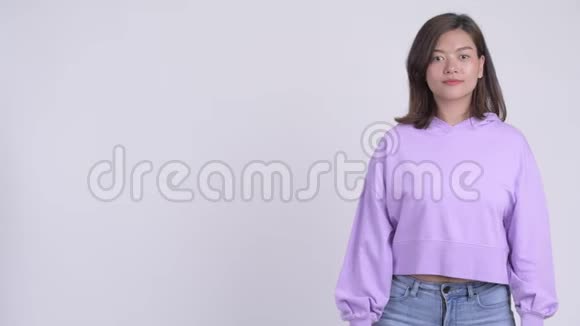 年轻快乐的亚洲女人展示了一些东西视频的预览图