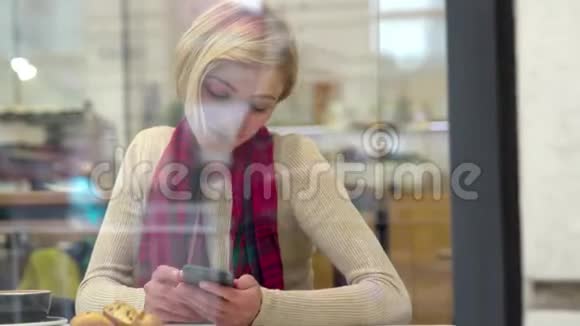 人和技术美丽的女人在咖啡厅用电话视频的预览图