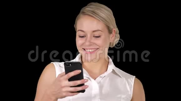 快乐的年轻美女微笑着用手机阿尔法频道视频的预览图