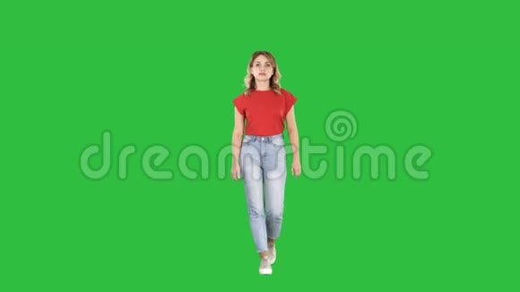 随意的女人在绿色屏幕上行走和微笑Chroma键视频的预览图