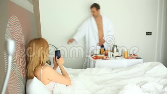 年轻夫妇在公寓的床上吃早餐视频的预览图