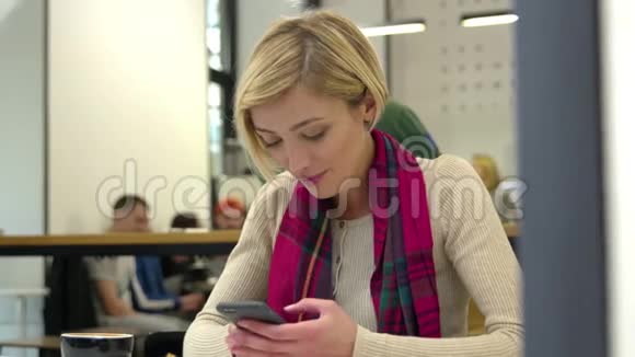 技术在室内咖啡厅使用手机的微笑女人视频的预览图