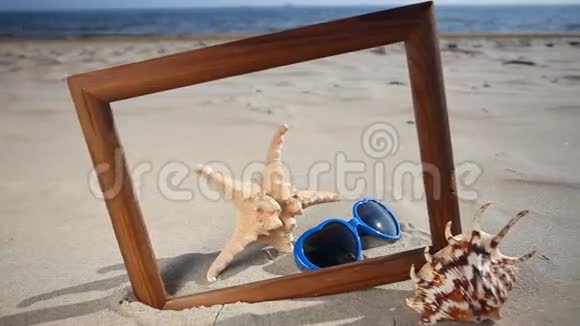 海滩上有贝壳海星和太阳镜的框架视频的预览图