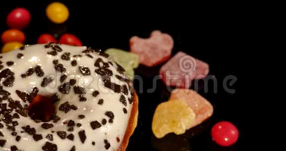 带有巧克力糖霜或糖霜的白色釉面甜甜圈条纹焦糖蜜饯葡萄干或花生的彩色粥视频的预览图