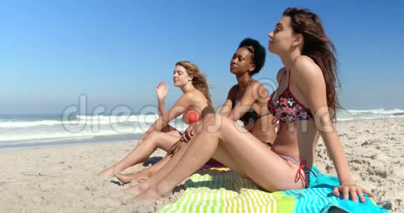 年轻女性朋友一起坐在沙滩上视频的预览图