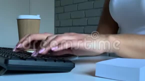 坐在办公桌前用笔记本电脑打字的女人视频的预览图